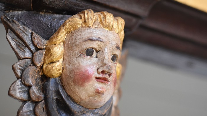 En smuk udskåret figur af en kvinde med gyldne hår og blå øjne.