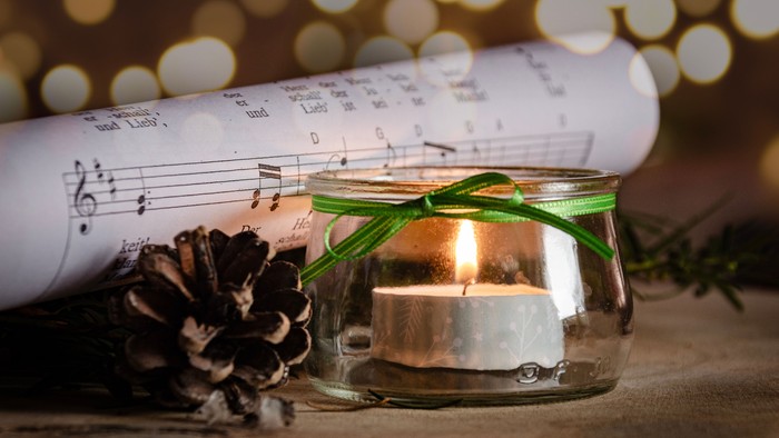 Teelicht im Glas vor Notenblatt