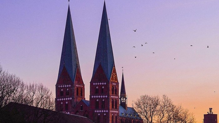 Zwei hohe Kirchtürme bei Sonnenuntergang