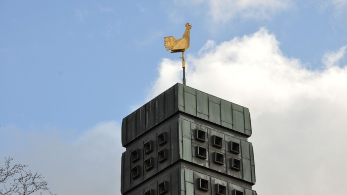 Goldene Statue auf modernem Gebäude unter blauem Himmel