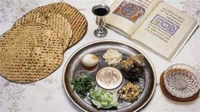 Billedet viser en passover-måltid med matzoh, korn og en bog.