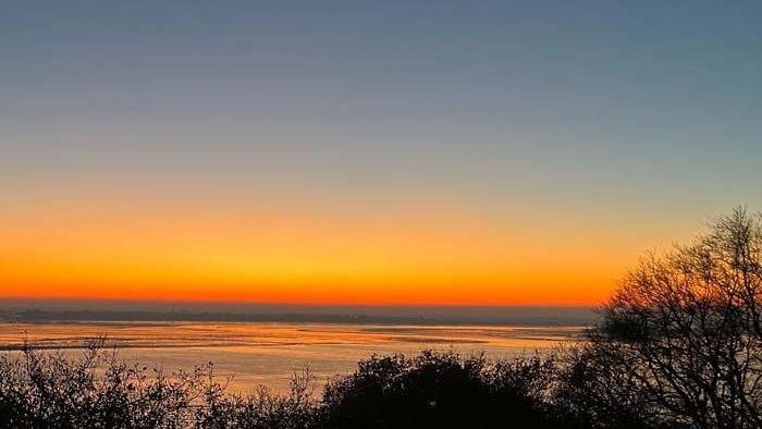 Ein wunderschöner Sonnenuntergang über dem Meer mit leuchtenden Farben am Himmel.