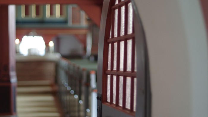 Eine Treppe mit einem Fenster und Geländer, die in einem Gebäude nach oben führt.