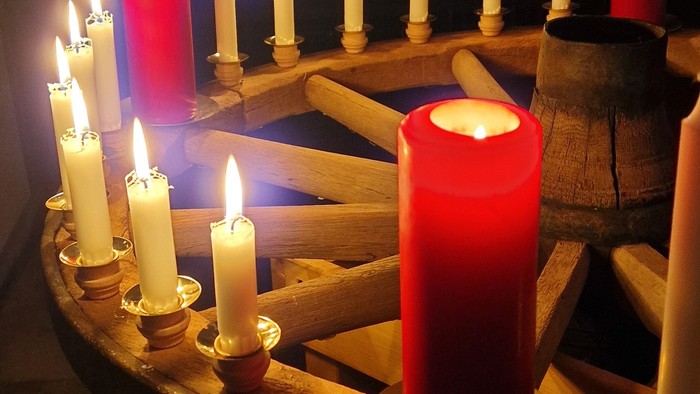 Brennende Kerzen auf einem alten Wagenrad.