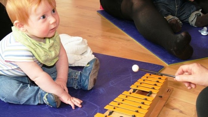 Børn spiller på marimba med hjælp fra en voksen