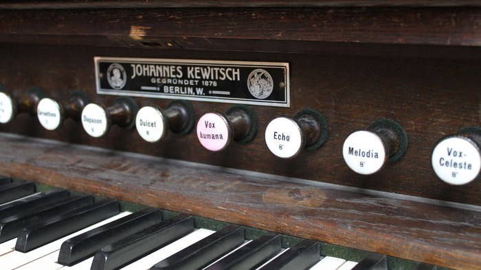 Altes Harmonium mit Aufklebern und schwarzer Tastatur