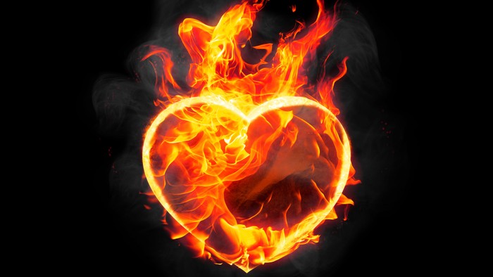 Ein brennendes Herz vor schwarzem Hintergrund