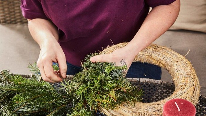 Person bastelt einen Tannenbaumkranz