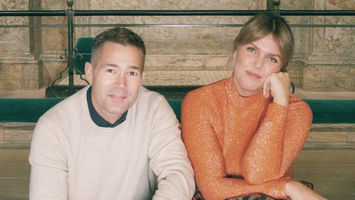 En mand og en kvinde sidder på en bæn i en kirke.