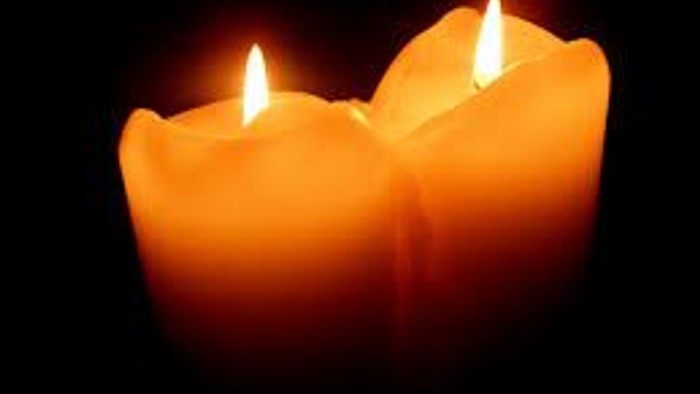 To candler med lysende flammer på sort baggrund