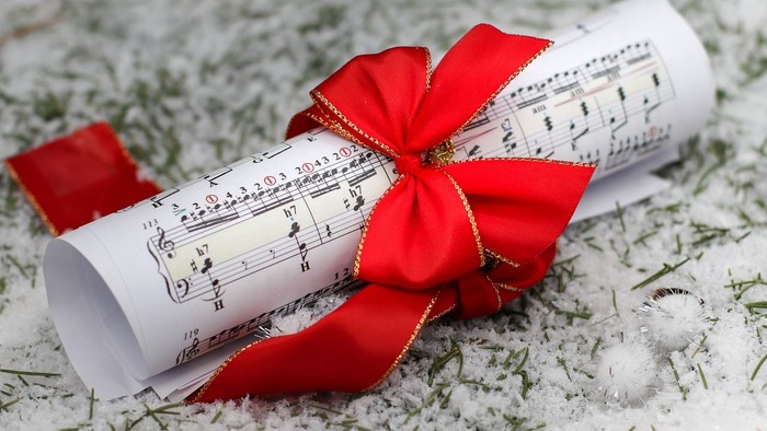 Noderuller bundet med rød sløjfe, placeret på snebedækket overflade.