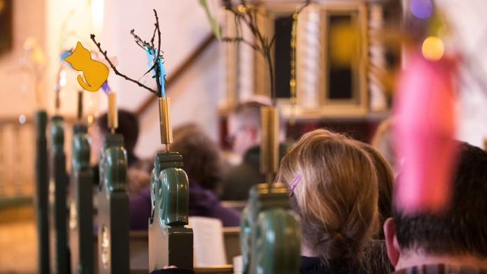 En person sitter ved et bord med glas med blomsterarrangeringer.