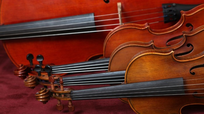 Zwei Geigen, Viola und Cello auf dem Boden hintereinander
