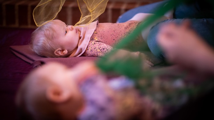 To børn ligger i en køje med blomster.