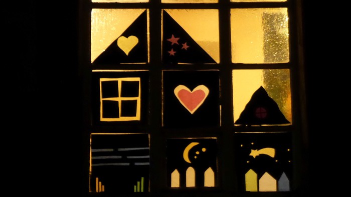 Ein Fenster mit Buntglas, das Herzen, Sterne und einen Mondsichel zeigt.