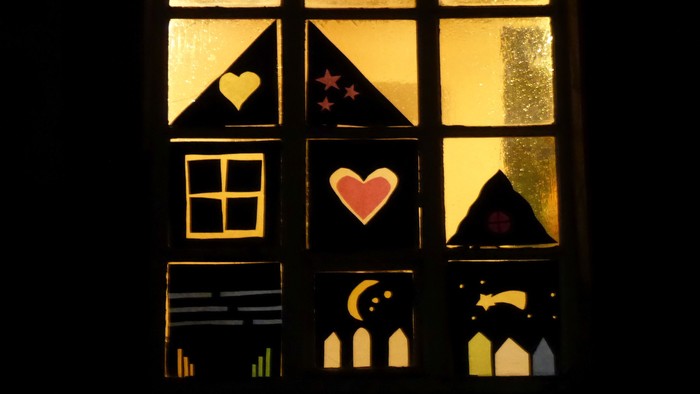 Ein Fenster mit Buntglas, das Herzen, Sterne und einen Mondsichel zeigt.