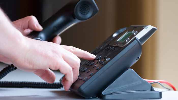 Hand tippt auf Telefon-Tastatur