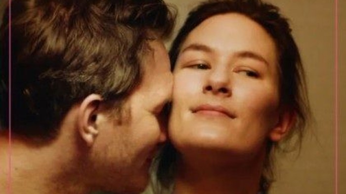 Et romantisk filmplakat med et par i et intimt øjeblik.