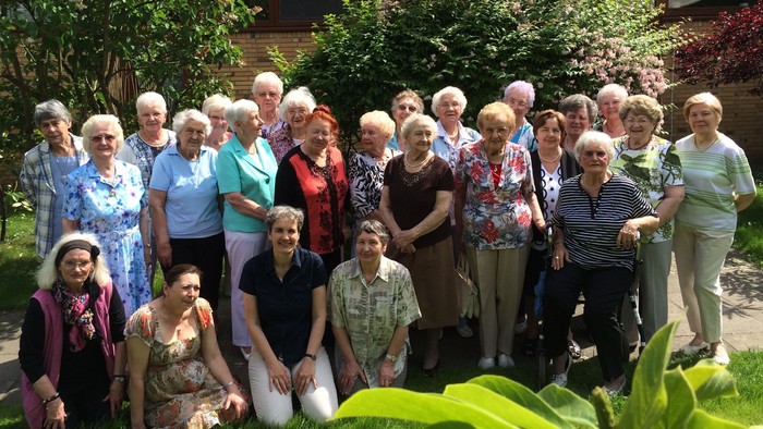 Eine Gruppe älterer Menschen posiert im Garten