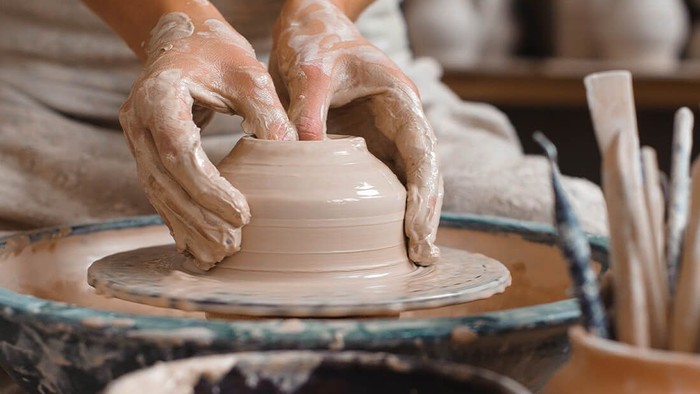 Eine Person formt auf einer Töpferscheibe aus Ton eine Schale