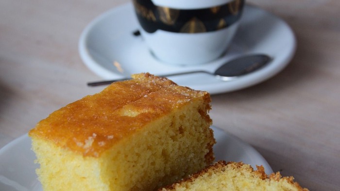Kaffee – Gedeck: im Vordergrund, ein aufgeschnittene Stückkuchen im Hintergrund eine Tasse Kaffee.