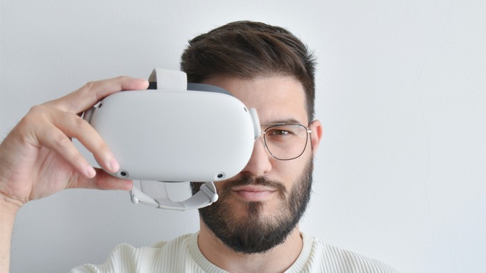 Mann hält VR-Headset vor dem Gesicht.
