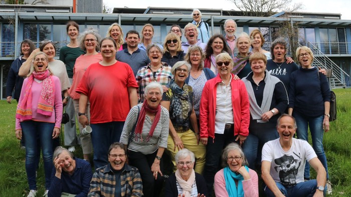 Eine Gruppe von Menschen posiert vor einem Gebäude mit Solarpaneelen