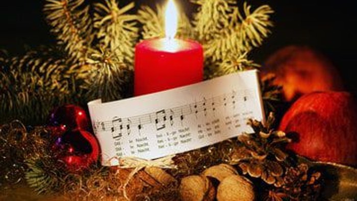 En rød lysende candlestick med noter og nødder til jul