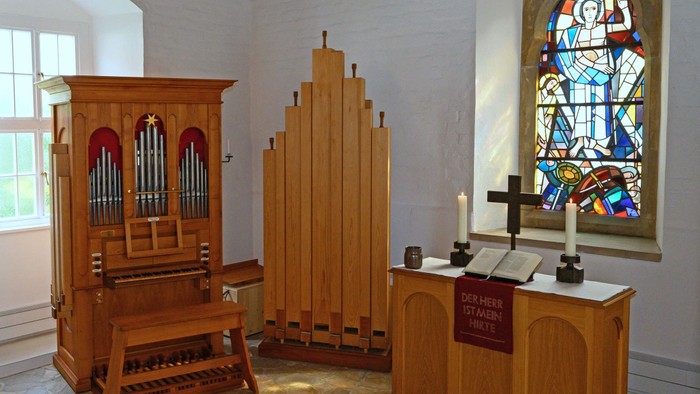 Orgel, Kirchenfenster, Altar, Kerzen, Holzmöbel