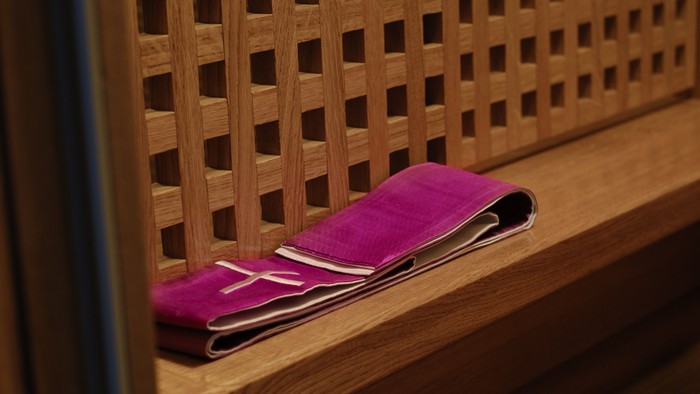 Ein rosa Handtuch liegt auf einer hölzernen Bank mit Gittermuster.