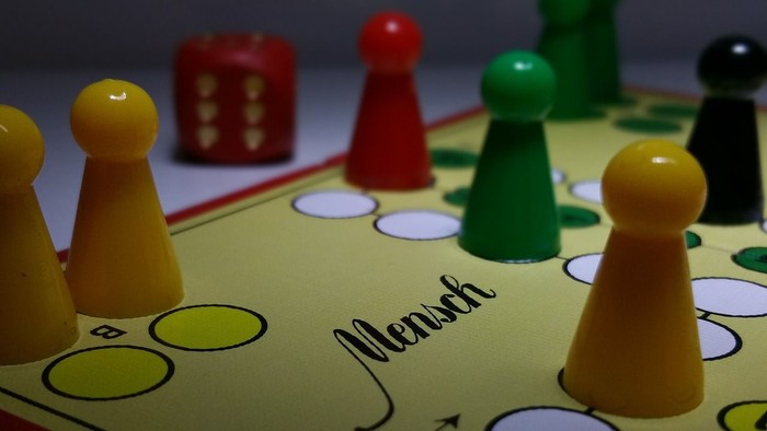 Das Bild zeigt ein Gesellschaftsspiel mit verschiedenen Spielfiguren und einem Spielbrett.