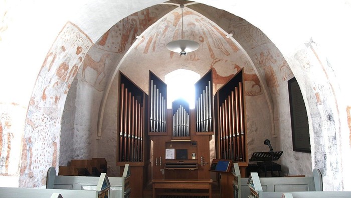 Bygning med orgel og malerier på vægge