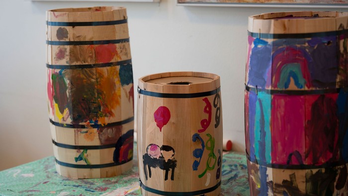 Håndmalede træfade med farverige børnekunstmotiver, arrangeret på et bord.