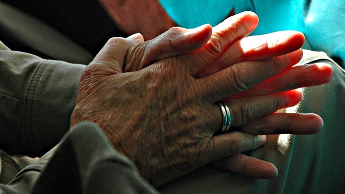 En person holder en ældres hånd.