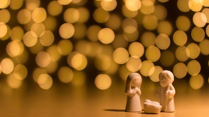 Zwei Holzfiguren vor goldenem Bokeh-Hintergrund