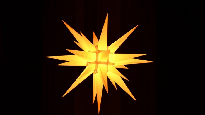 Ein leuchtender gelber Stern vor dunklem Hintergrund