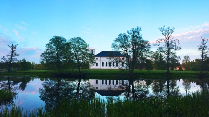 En stor, hvid bygning ved en sø i natlys