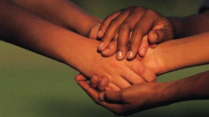 Fire hånders håndflader sammen, symboliserende enhed og støtte
