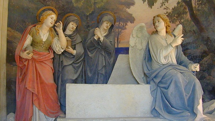 Fire kvinder i religiøse poser, en med vingesæt.