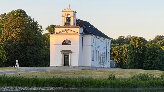 En lille kirke ved en sø i en park