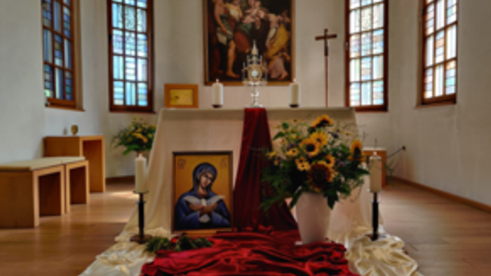 Ein Altar in einer Kirche mit Blumen, Bildern und Kerzen