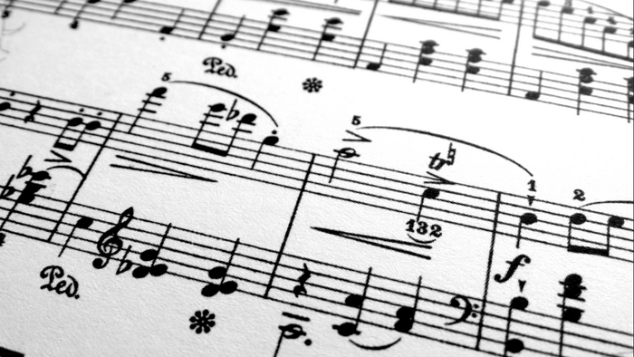 Nahaufnahme komplexer Notenblätter mit schnellen Noten und Vortragsbezeichnungen.