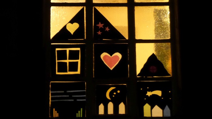 Ein Fenster mit Buntglas, das Herzen, Sterne und einen Mondsichel zeigt.