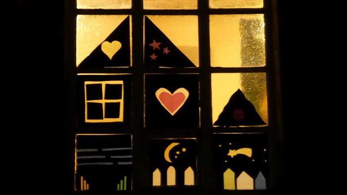 Ein Fenster mit Buntglas, das Herzen, Sterne und einen Mondsichel zeigt.