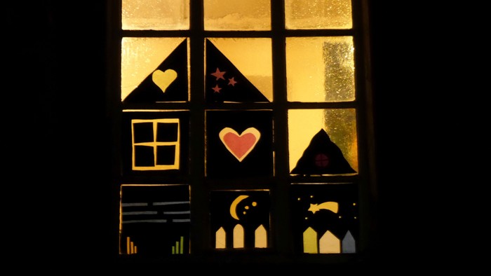 Ein Fenster mit Buntglas, das Herzen, Sterne und einen Mondsichel zeigt.