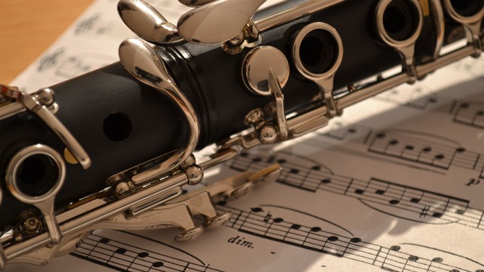 Et nærbillede af en klarinet, der hviler på nodestade med noder og en diminuendo-markering.