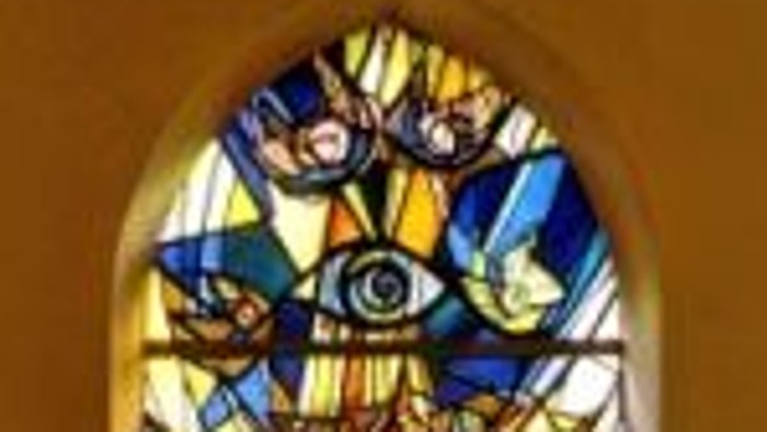 Das Buntglasfenster zeigt eine religiöse Szene mit Jesus Christus am Kreuz