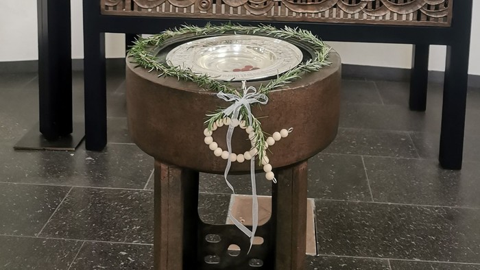 Ein Altar mit Kreuz, Kerzen und Blumen in einem Raum