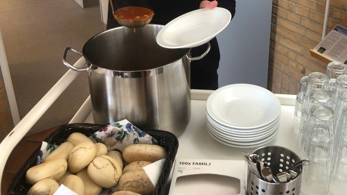 Køkkenhjælper serverer mad i kantinen