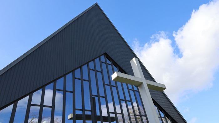 En moderne kirke med store glassider og to store kors.